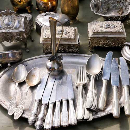 Old Silver kitchen utensils on a silver tray with some silver boxes to be refurbished.